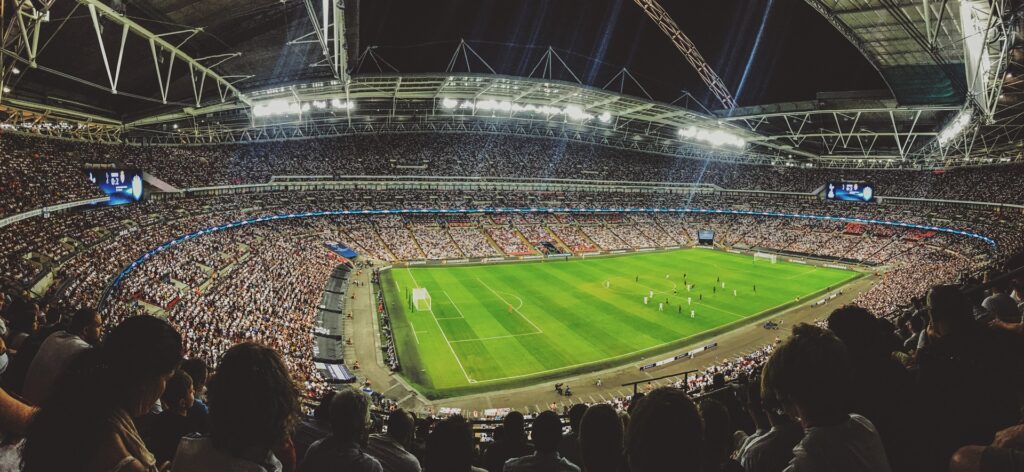 Et stort fodbold stadion med publikum. Fodbold kampen bliver brugt til odds og tips på resultatet.